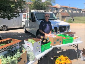 Bob Hoffman hands fresh produce out at a Neighborhood Center's Back to School Bash