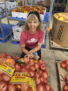 Nora with onion from Twin County Produce Auction farmers