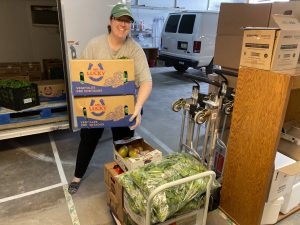Nicki Ross prepares boxes of produce for distribution.