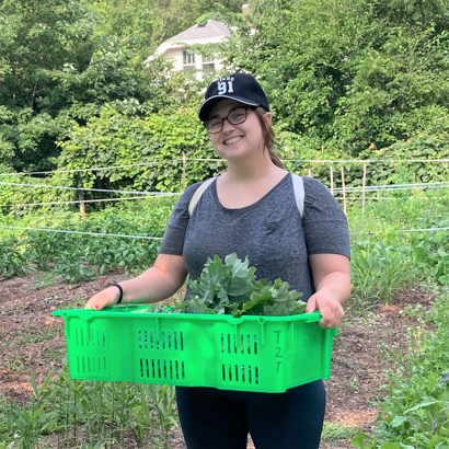 Molly Suter holds a tray of greens at an urban farm