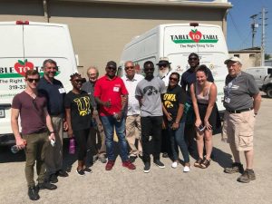 Benny stands with a group of Mandela Washington Fellows and T2T staff members outside by the T2T fleet