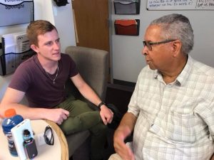 Benny chats with another volunteer in the T2T office