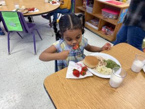 A preschooler enjoys a full meal from that day's T2T food deliveries