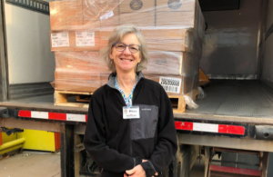 Dina poses in front of our straight truck, loaded with a pallet of food.