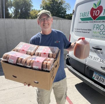 Jared Long holding donuts and apple cider to deliver to Coralville Pantry.