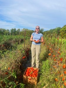 Natalie on a glean at Wildwoods Farm showing off the tomatoes she harvested.