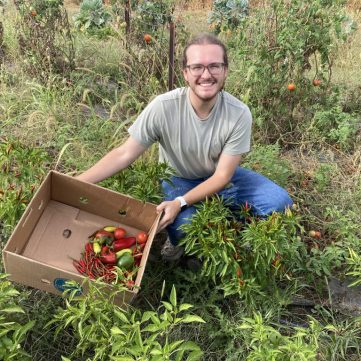 Ryan posing at a glean with harvested produce.