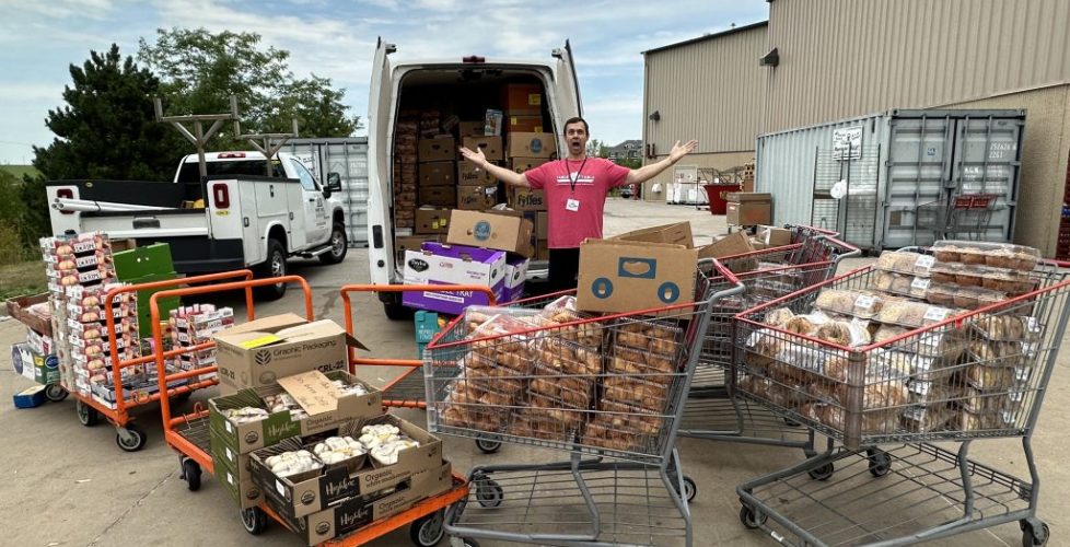 Volunteer in front of T2T van with lots of overflowing shopping carts.