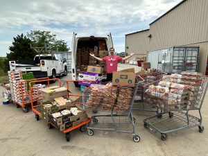 Volunteer in front of T2T van with lots of overflowing shopping carts. 