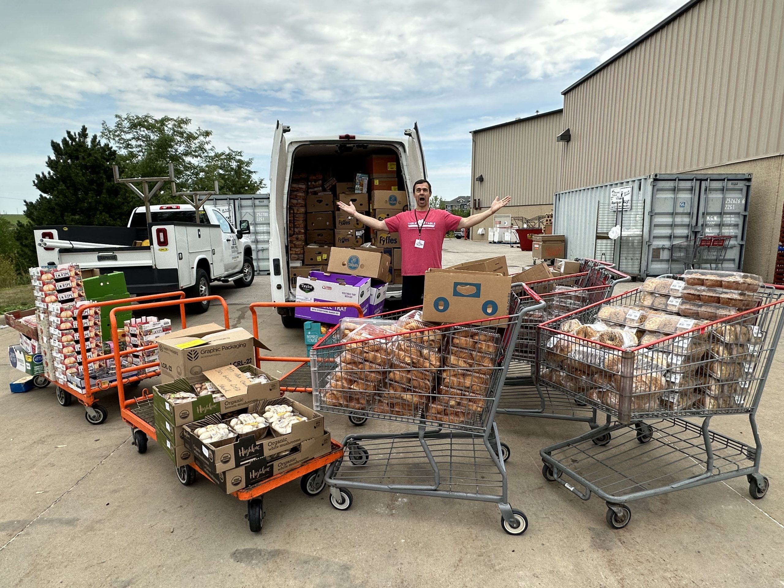 Volunteer in front of T2T van with lots of overflowing shopping carts.