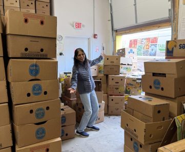 Volunteer Rajni Vijh amongst many banana boxes in the T2T shop.