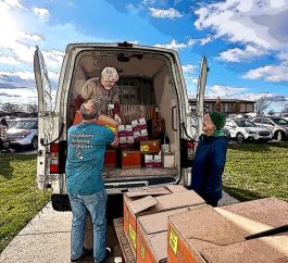 two volunteers delivering food to north liberty pantry.